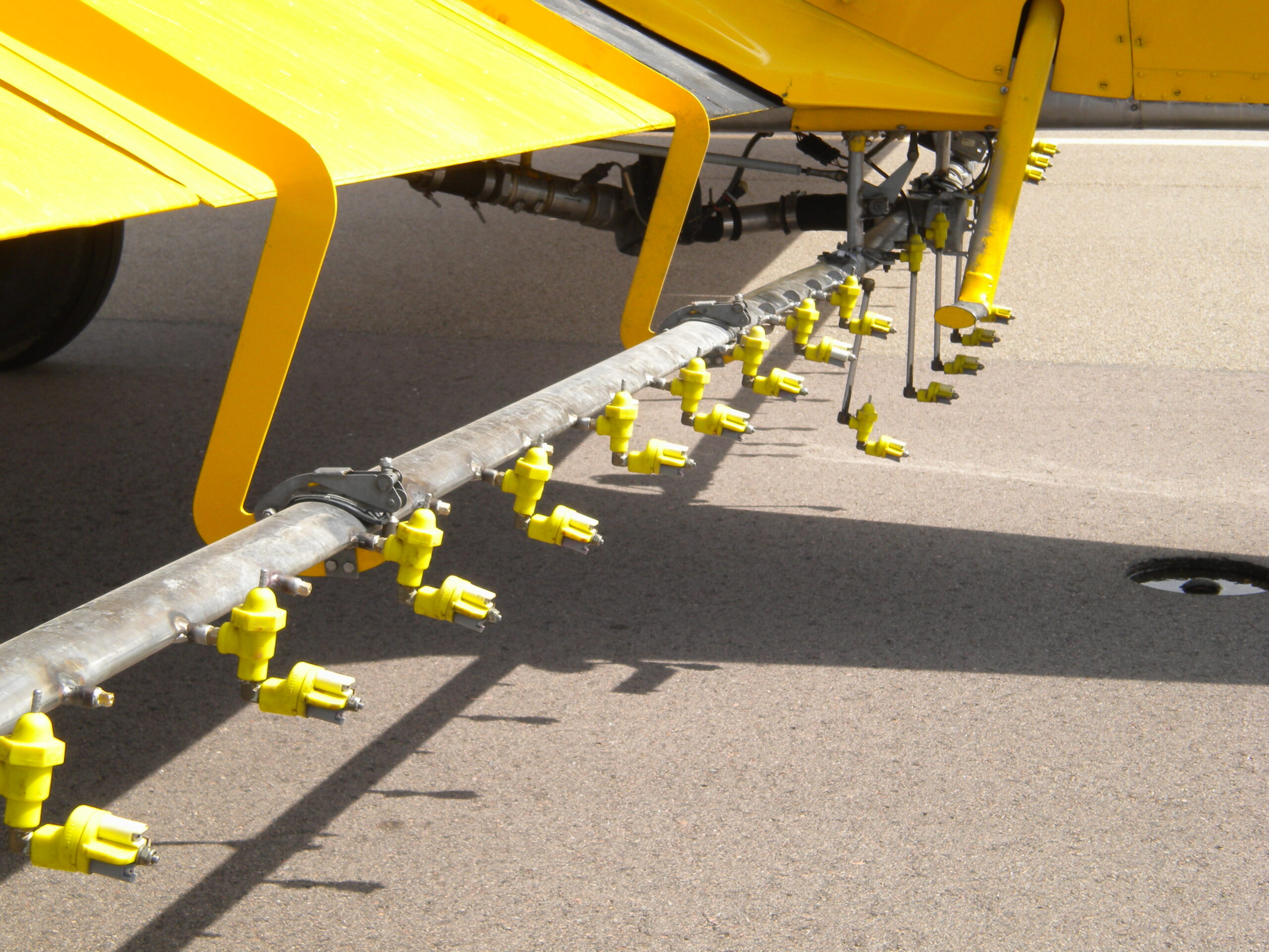 Close-up of CP-11TT spray nozzles with CP check valves installed along agricultural spray boom.